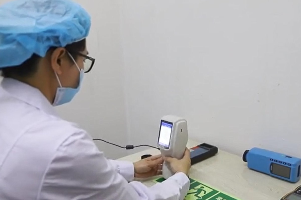 technician is testing the luminance of the photoluminecent sign