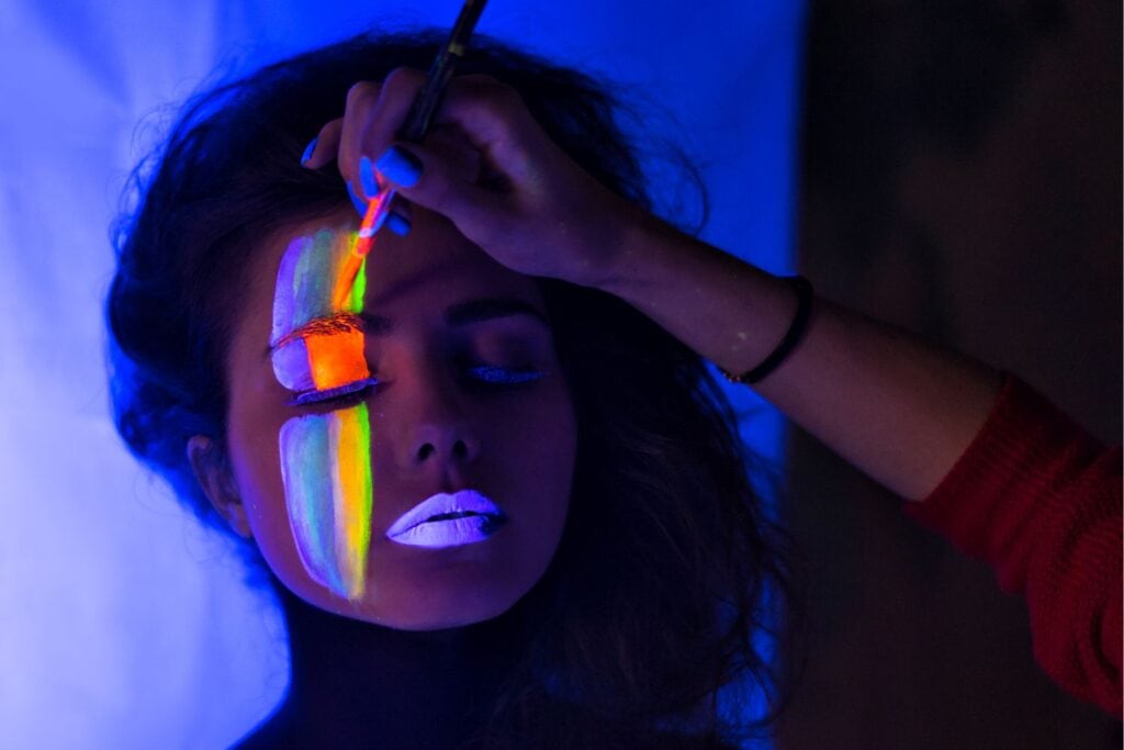 artist painting a women with uv light