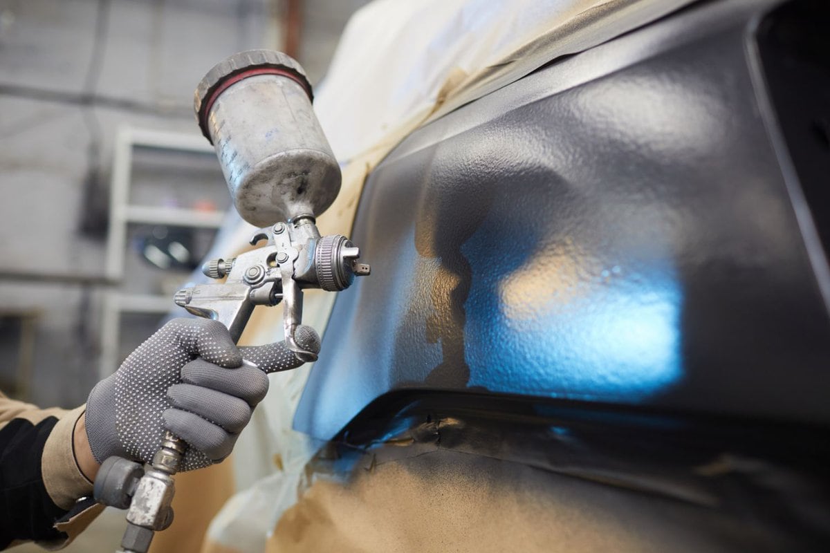 unrecogonicable men painting car